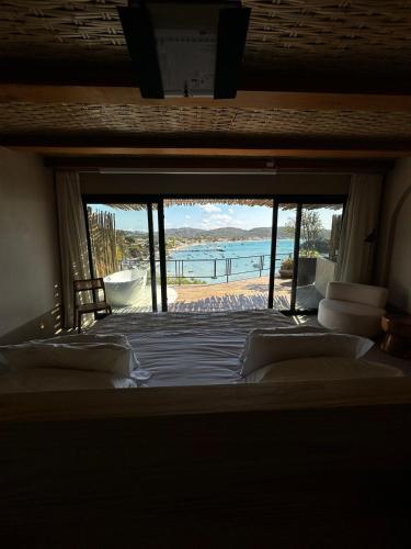 a bedroom with a large bed with a view of a beach at Abracadabra Boutique Hotel in Búzios