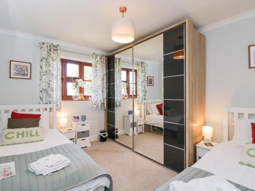 a bedroom with two beds and a mirrored closet at The Old Byre in Salisbury