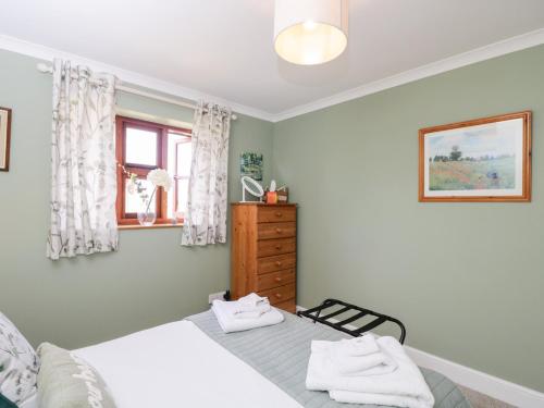 a bedroom with a bed and a dresser and a window at The Old Byre in Salisbury