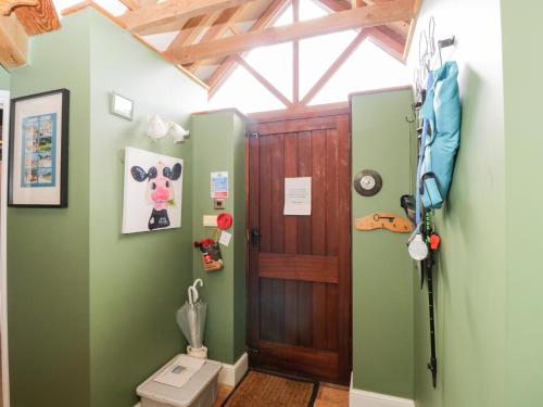 a bathroom with a toilet and a wooden door at The Old Byre in Salisbury