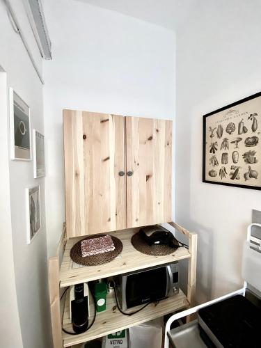 eine Küche mit einem Holzschrank und einer Mikrowelle in der Unterkunft Michelangelo Green Corner in Casalecchio di Reno