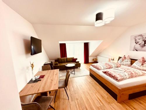 a bedroom with a bed and a dining room at Liesingtal Premium Room in Vorderlainsach