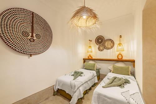une chambre avec deux lits et un lustre dans l'établissement Riad Amaya, à Marrakech