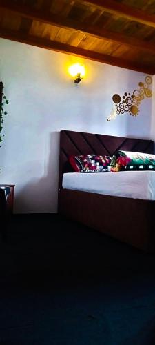 a bedroom with a bed and a light on the wall at The Mount Lodge in Nuwara Eliya