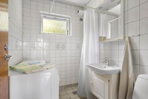 a white bathroom with a toilet and a sink at 6843-Allinge-Lundegardsvej-16-B in Sandkås