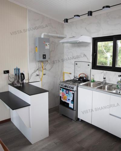 a white kitchen with a stove and a sink at Cabaña Vista ShangriLa, Las Trancas in Las Trancas