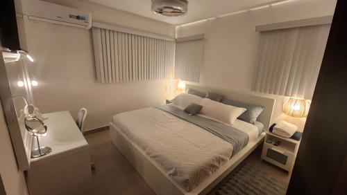 a small bedroom with a bed and a table at Santiago Family-Friendly in Pontezuela Arriba