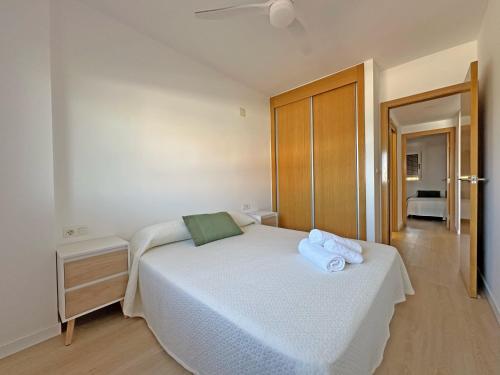 a bedroom with a white bed with towels on it at Sol y Mediterráneo in Oropesa del Mar