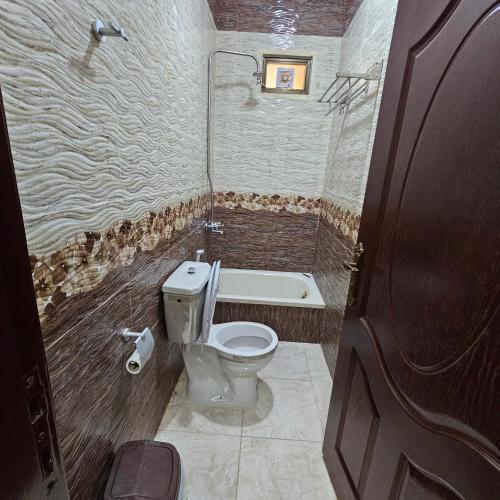 a bathroom with a toilet and a bath tub at Authentic boutique in Wadi Musa