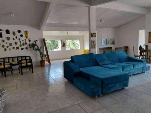 a living room with a blue couch and a table at Casa para temporada in Guarapari