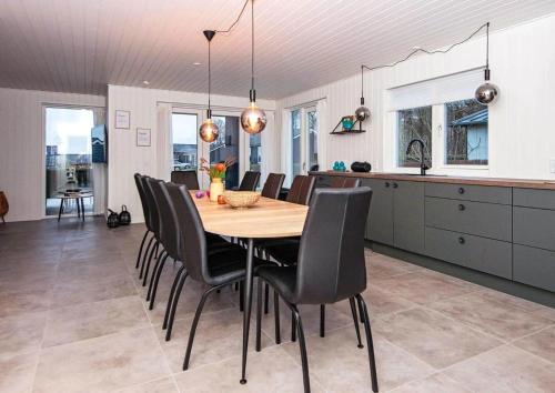 a kitchen and dining room with a wooden table and chairs at SJ302-Haderslev-Blokhusskoven-63 in Kelstrup Strand