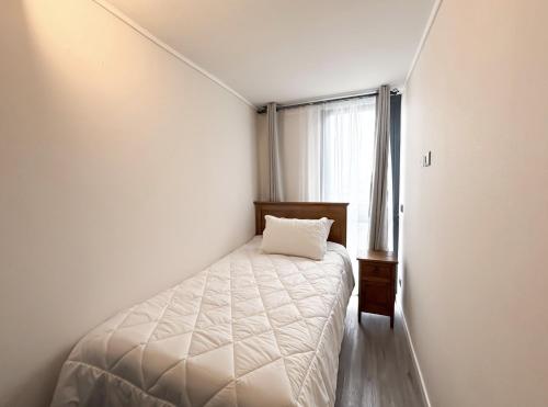 une petite chambre avec un lit et une fenêtre dans l'établissement Departamento con Excelente conectividad, Metro Santa ana, à Santiago