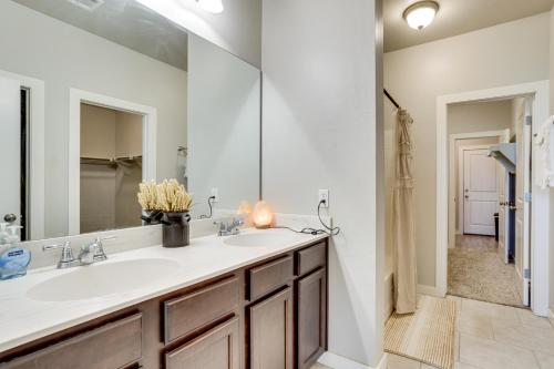un bagno con un lavandino e un grande specchio di Golf, Swim, Relax Oklahoma Ranchland Retreat a Edmond