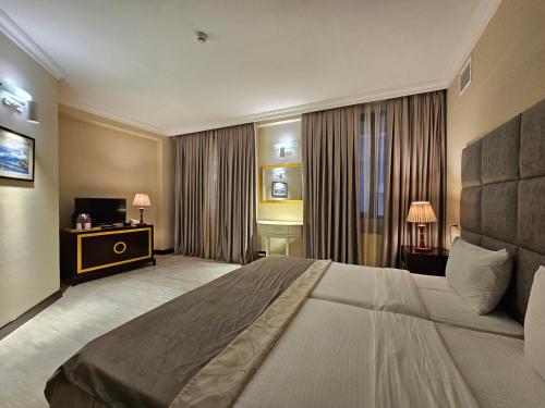 a hotel room with a large bed and a television at Crown Suites Apart Baku in Baku