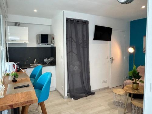 ein Wohnzimmer mit einem Tisch und blauen Stühlen in der Unterkunft Studio - Centre - Gare - wifi in Lorient