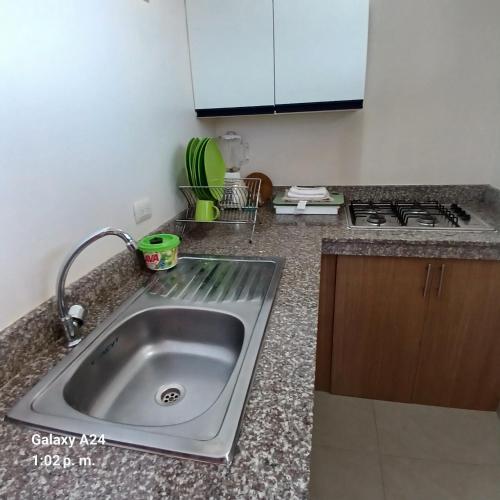 a kitchen with a sink and a stove at Suites Sonikikos in Ballenita