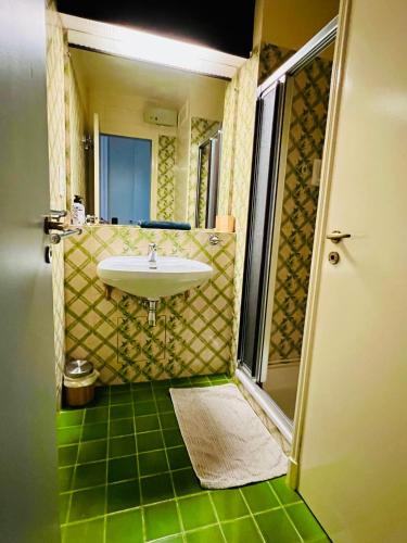 un bagno con lavandino e pavimento verde di Le Marine 4 a Cogolin