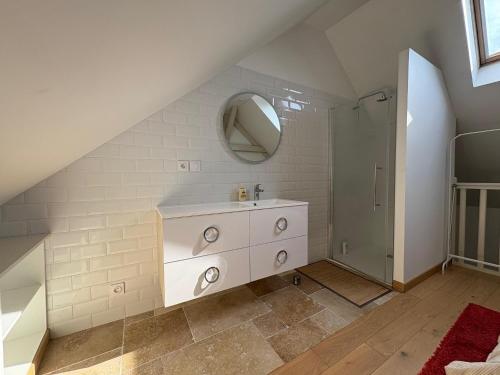 a white bathroom with a sink and a mirror at Charmant Cottage in Olivet