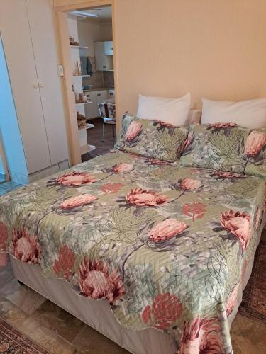 a bedroom with a bed with a floral comforter at Steijn Apartment 1 in Standerton