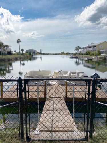 a boat docked in a river with a fence at Waterfront and Gulfview Retreat Hernando Beach in Hernando Beach