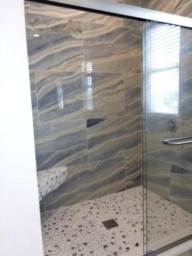 a shower with a glass door in a bathroom at Waterfront and Gulfview Retreat Hernando Beach in Hernando Beach