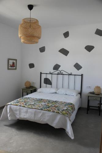a bedroom with a bed withestones on the wall at Casa Antonio-Tinajo in Tinajo