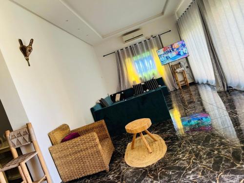 a living room with a chair and a stool at Spacious and comfortable villa in Marrakech