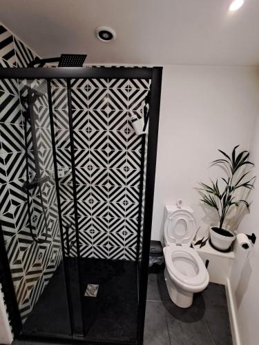 ein Badezimmer mit Toilette und einer schwarz-weißen Wand in der Unterkunft Whole Annexe in our family home & private entrance in Ipswich