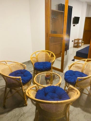 a group of chairs and a table with blue seats at Hotel Hanguk Villa in Dambulla