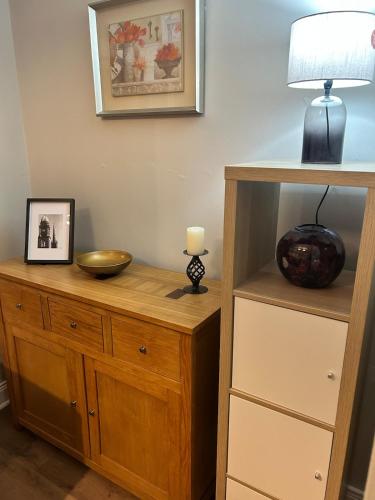 a cabinet with a lamp and a bowl on it at Beautiful little cosy gem in the heart of Lisburn in Lisburn