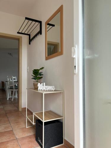 a hallway with a table and a mirror on a wall at Gemütliche Ferienwohnung in Neitzert