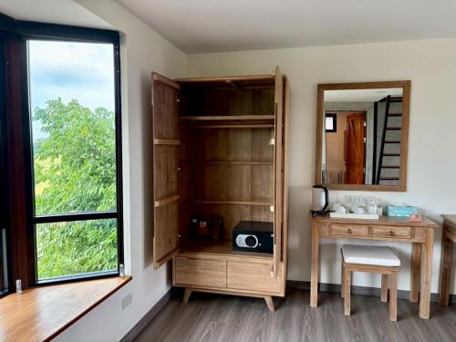 a room with a desk and a mirror and a window at Nature Peace Home in U Thong