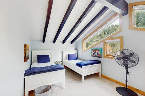 a bedroom with two beds and a fan at Booth Falls Chalet in Mid Vail