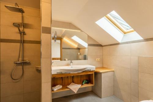 a bathroom with a sink and a shower with a skylight at Gasthof Neuwirt in Eugendorf