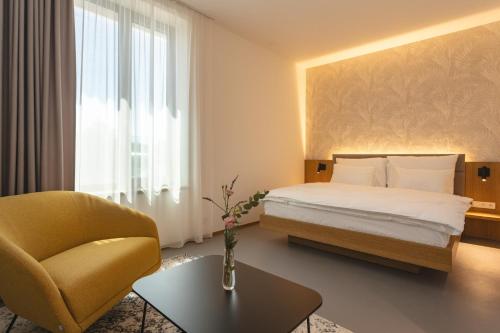 a hotel room with a bed and a chair at Hotel Bronzo Brno in Brno