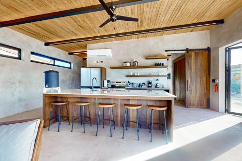 a kitchen with a island with bar stools at Seabird - Villa 17 in Placencia Village