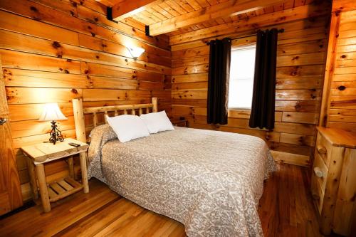 a bedroom with a bed in a log cabin at The Cabins at Pine Haven - Beckley in Beaver