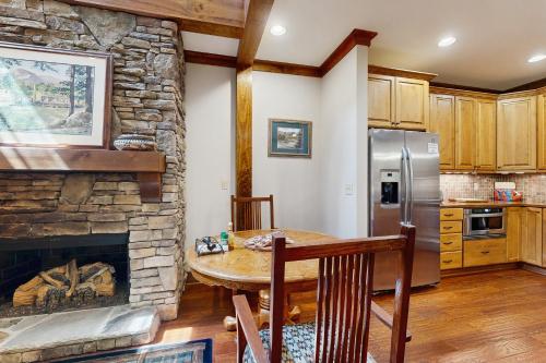 a kitchen with a table and a stone fireplace at Firefly Cove #202 in Chimney Rock