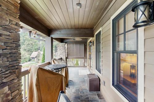 a screened porch with a stone wall and windows at Firefly Cove #202 in Chimney Rock