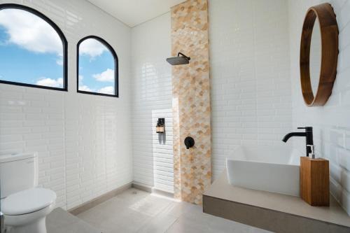 a white bathroom with a sink and a toilet at Honey Villa Canggu in Canggu