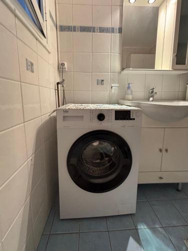 a washing machine in a bathroom with a sink at Nagomi Centre Spot in Kavála