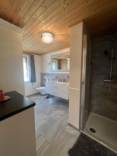 a bathroom with a shower and a sink at Chalet Schluechtyi in Langwies