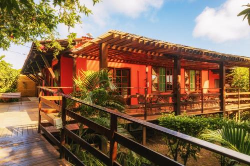 a red house with a deck and patio at Pousada Mabuya in Fernando de Noronha