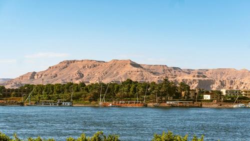 a large body of water with mountains in the background at Al Fayrouz Palace Apartments in Luxor