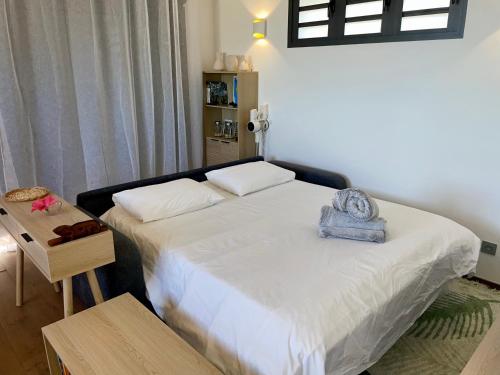 a bedroom with a bed with a blue towel on it at La Kazadoo in Piton Saint-Leu