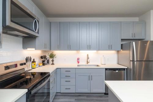 a kitchen with blue cabinets and stainless steel appliances at Trinity River - Skyline Views - King bed in Fort Worth
