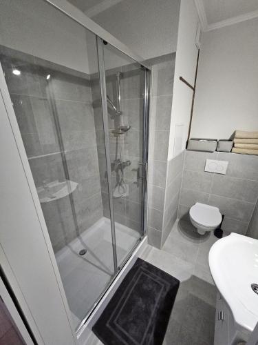 a bathroom with a shower and a toilet and a sink at Apartment Park - Air-conditioned in Šamorín