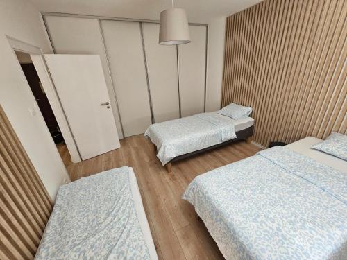 a room with two beds and a door in it at Apartment Park - Air-conditioned in Šamorín