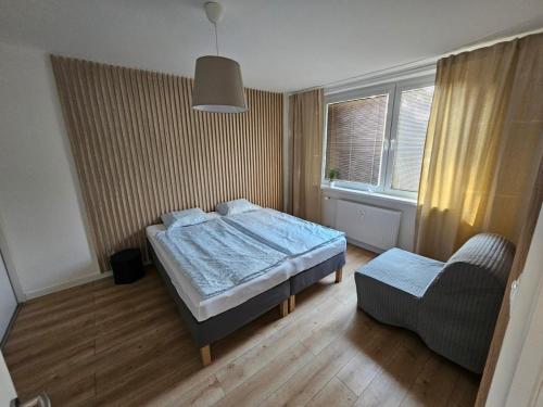 a small bedroom with a bed and a chair at Apartment Park - Air-conditioned in Šamorín