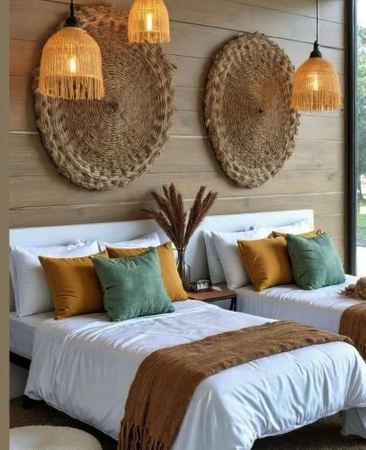 two beds in a bedroom with hanging baskets at Pousada Casa de Geralda in Altaneira